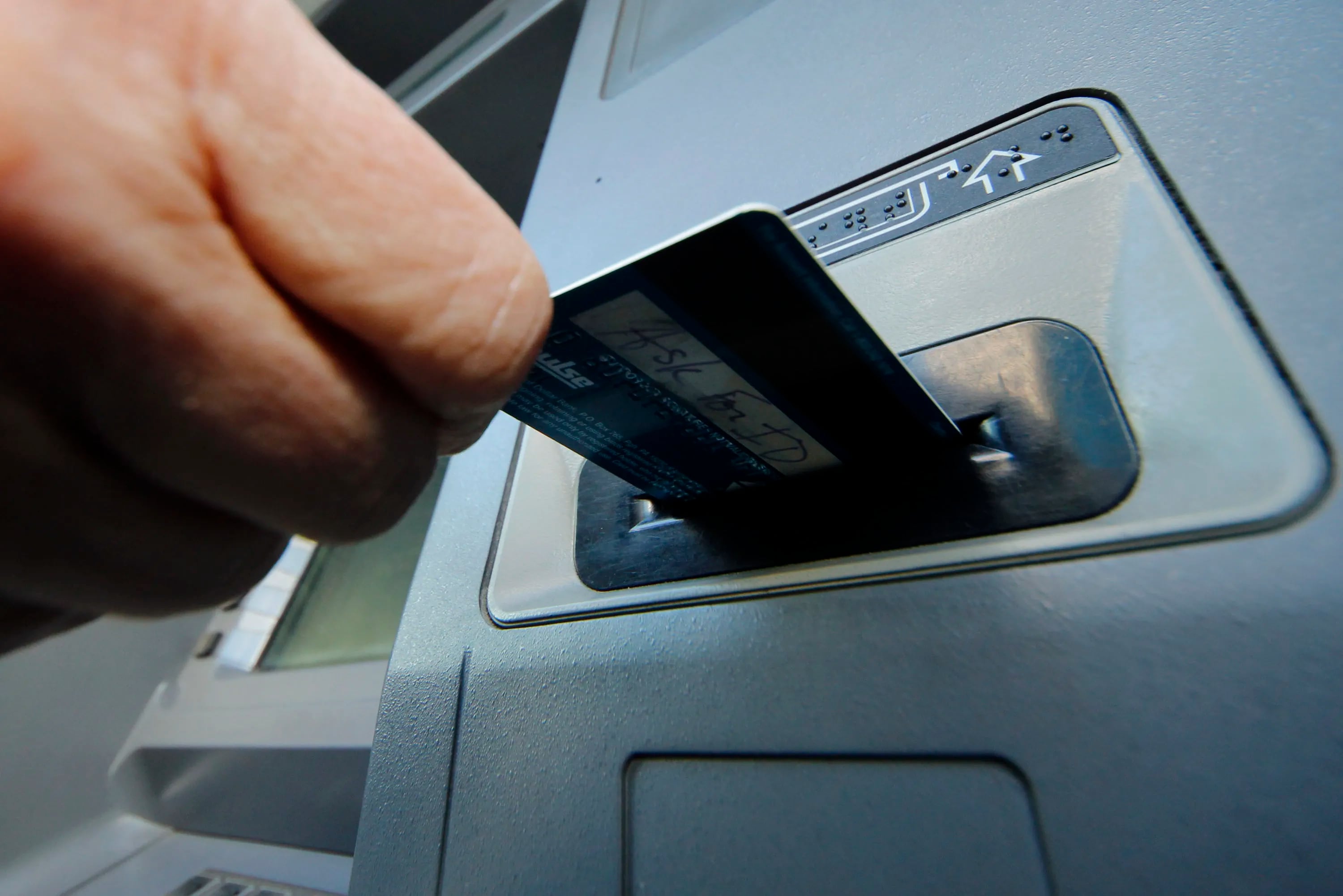 A person inserts a debit card into an ATM in Pittsburgh in this 2013 file photo.