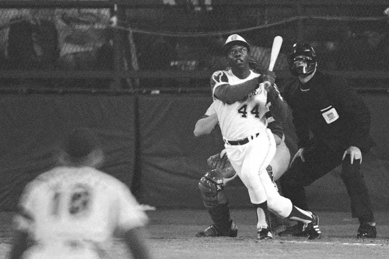 The Atlanta Braves' Hank Aaron eyes the flight of the ball after hitting his 715th career homer in a game against the Los Angeles Dodgers in Atlanta, Ga., in this April 8, 1974 file photo. Dodgers pitcher Al Downing, catcher Joe Ferguson and umpire David Davidson look on. Hank Aaron, who endured racist threats with stoic dignity during his pursuit of Babe Ruth but went on to break the career home run record in the pre-steroids era, died early Friday, Jan. 22, 2021. He was 86. The Atlanta Braves said Aaron died peacefully in his sleep. No cause of death was given.