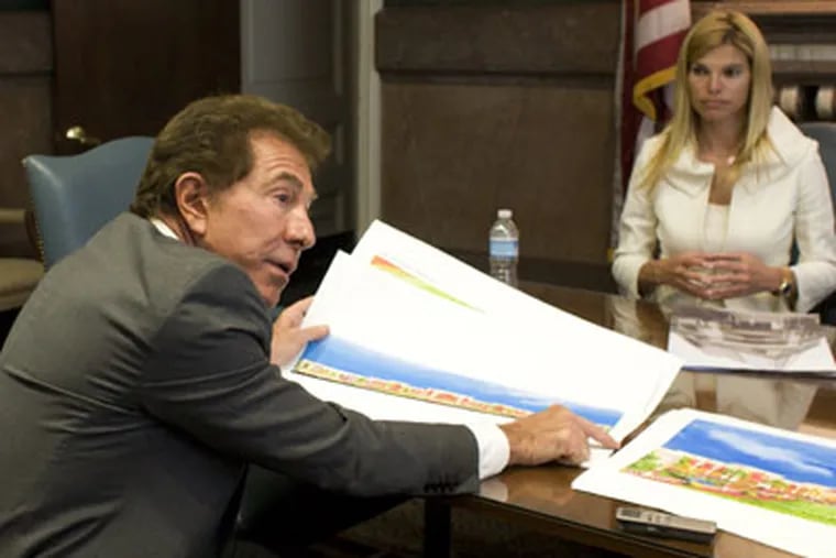 Steve Wynn spreads out color renderings of his plans for the remade Foxwoods Casino in Pennsport.  His girlfriend Andrea Hissom looks on. (Ed Hille / Staff Photographer)