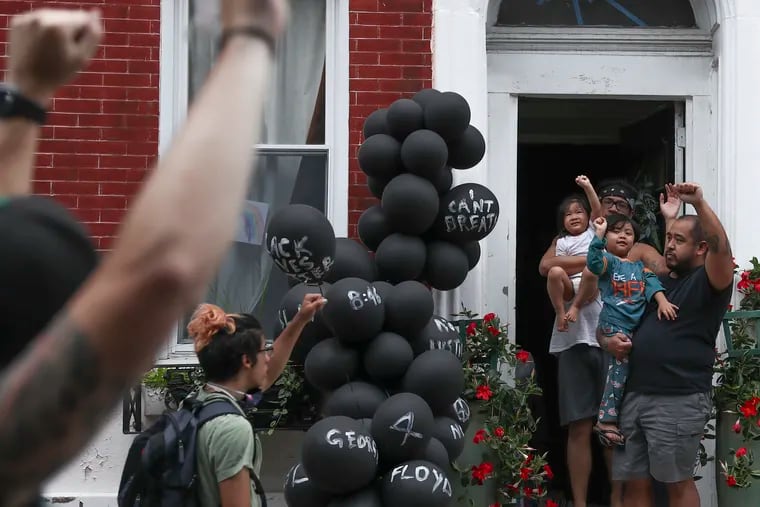 A family raises their fists in solidarity with thousands of protesters as they make their way throughout Philadelphia on Tuesday, June 02, 2020. Protests have been taking place across the country over the death of George Floyd at the hands of Minneapolis police.