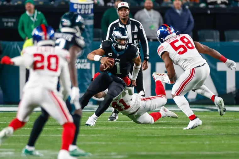 Eagles quarterback Jalen Hurts escapes from New York Giants linebacker Micah McFadden late in the second quarter Monday night.