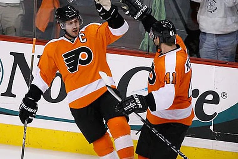 Mike Richards celebrates with Andrej Meszaros after scoring a goal in the third period. (Matt Slocum/AP)