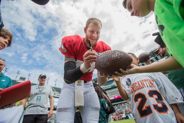 Eagle quarterback Carson Wentz #11, signs autographs on the field after the second open practice at Lincoln Financial Field on Sunday.  MICHAEL BRYANT / Staff Photographer