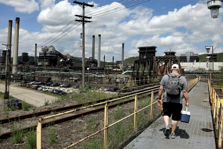 FILE - In this May 2, 2019, file photo a worker arrives for his shift at the U.S. Steel Clairton Coke Works in Clairton, Pa. A fire at U.S. Steel's massive coke plant outside Pittsburgh knocked a key pollution control system offline Monday, June 17, 2019. It triggered a health warning as officials monitored the air around the plant for signs of a release of toxic sulfur dioxide. It was the second fire since December at the coke works, the largest facility of its kind in the United States. The plant turns coal into coke, one of the raw materials of steel.