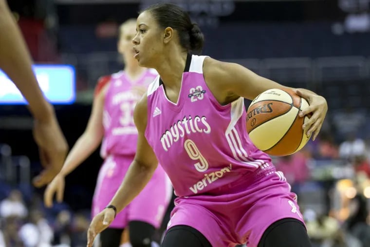 Washington Mystics guard Natasha Cloud controls the ball against the Phoenix Mercury in a WNBA game.