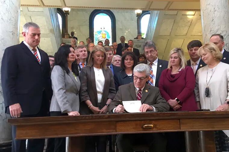 Mississippi Gov. Phil Bryant is surrounded by lawmakers on Thursday, March 21, 2019, as he signs a bill that would ban most abortions once a fetal heartbeat can be detected, at the capitol in Jackson, Miss. The bill is set to become law July 1, 2019 and would be one of the strictest abortion laws in the nation. The Center for Reproductive Rights calls the law unconstitutional and says it will sue Mississippi to try to block the law from taking effect.