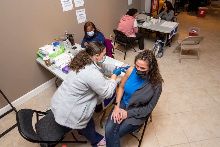 Nurse Jada DiRocco, left, administers a Pfizer vaccine booster to Allison Ebling at a Montgomery County COVID-19 vaccine clinic at the King of Prussia Mall on Wednesday.
