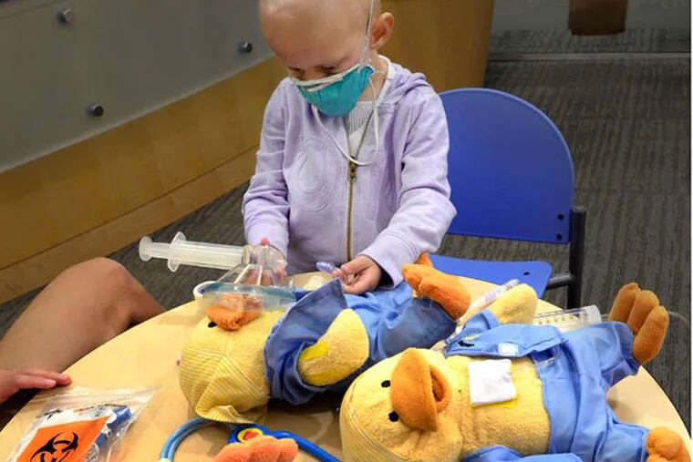Carlin Beasley , 3, practices delivering medicine with Chemo Ducks therapy dolls at Penn Medicine's Roberts Proton Therapy Center. CLEM MURRAY / Staff Photographer