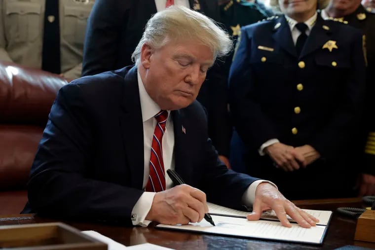 FILE - In this March 15, 2019, file photo, President Donald Trump signs the first veto of his presidency in the Oval Office of the White House in Washington. Trump issued the veto, overruling Congress to protect his emergency declaration for border wall funding.