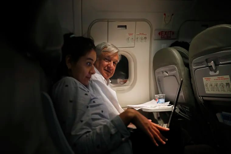 Mexican President Andres Manuel Lopez Obrador, center, sits with an assistant as he travels in economy class aboard a commercial flight from Guadalajara to Mexico City, Saturday, March 9, 2019. In his first 100 days in office, Lopez Obrador has answered more questions from the press, flown in more economy-class flights, posed for more selfies with admiring citizens and visited more genuinely risky areas with little or no security than several combined decades of his predecessors. (AP Photo/Marco Ugarte)