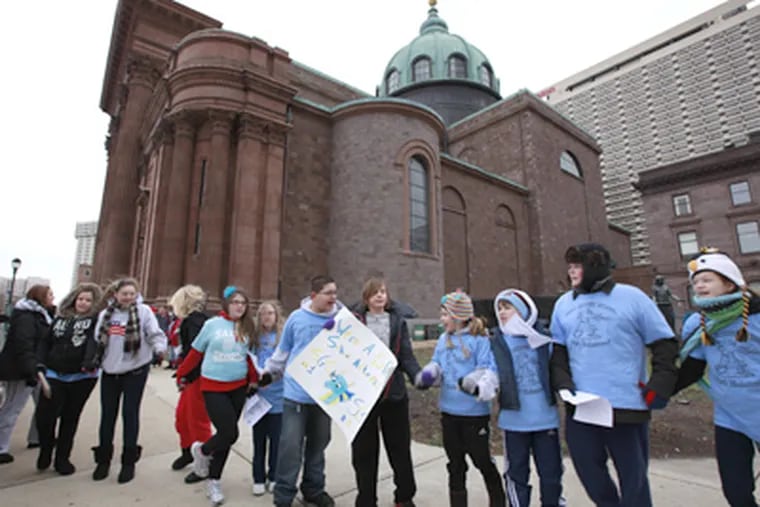 St. George School students and their supporters protesting outside the Cathedral of SS. Peter and Paul last week. (David Swanson / Staff Photographer)
