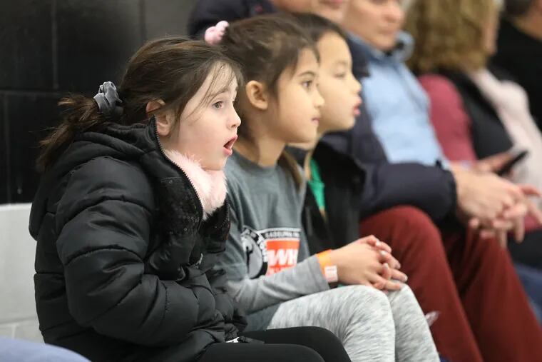(From left) Olivia Hefferan, 7; Alexis Duffy, 8; and Aiden Duffy, 8, from Media, watch an exhibition game during Saturday's "Dream Gap Tour."