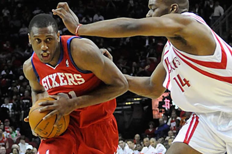 Thaddeus Young drives the ball around Houston Rockets' Carl Landry during the first half.  (AP Photo/Pat Sullivan)