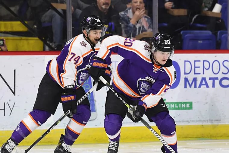 Jacob Pritchard (20) of the Reading Royals takes control of the puck as teammate Kenny Hausinger skates behind him.
