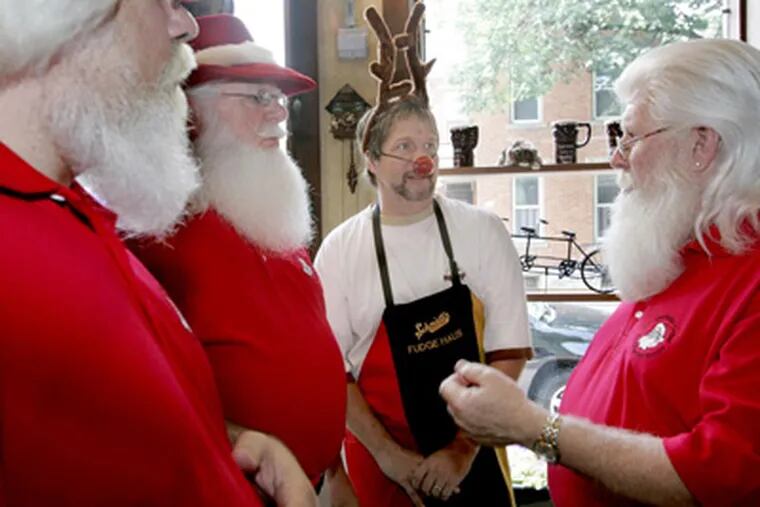 Members of the Amalgamated Order of Real Bearded Santas (all in red), from left to right, Nicholas Trolli, T. Christian Martens and Tim Connaghan, surround Tim Dick. (Renee Sauer / Dispatch photo)