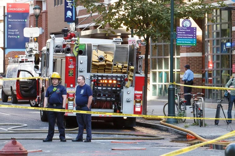 Philadelphia fire fighters stand around after responding to an underground cable fire at 9th and Walnut Streets in Center City Philadelphia on Wednesday, Oct. 4, 2017.