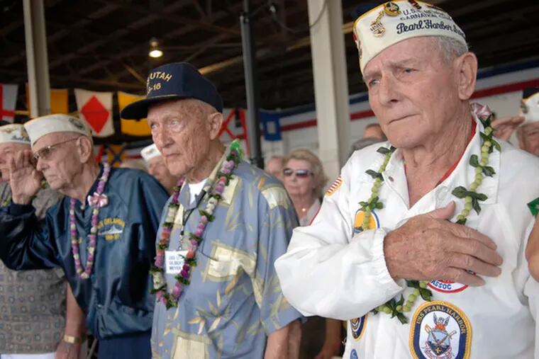 At the Pearl Harbor commemoration in Hawaii, Woody Derby, 90, (far right) places his hand over his heart. Derby was serving on the USS Nevada on Dec. 7, 1941, and comes back annually.
