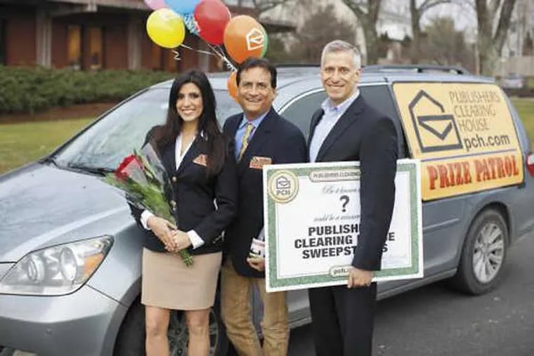 The primary Prize Patrol people, with flowers, balloons, champagne and check stand in front of their van
From PCH May 2017