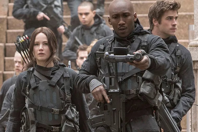 This image released by Lionsgate shows Jennifer Lawrence as Katniss Everdeen, from left, Mahershala Ali as Boggs, and Liam Hemsworth Gale Hawthorne in a scene from "The Hunger Games: Mockingjay Part 2."