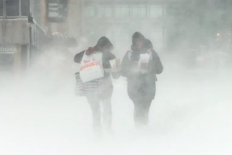 Liz Reed (left) of Carlisle, Pa., and Kayla Decker of Dover, Pa., walking amind a snowstorm in Atlantic City last month.