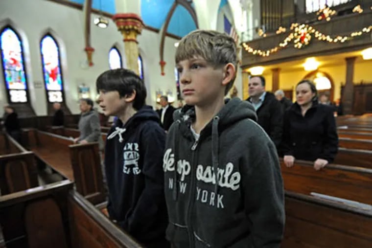 RRXSOUTH09P1  In Philadelphia, Catholics at churches that have been affected by the closures attend mass.  Here, at Sacred Heart of Jesus in South Philadelphia, Joey Fisher, 12; and Ross Dougherty, 11.  They are sixth graders at Sacred Heart of Jesus Elementary School, which is closing.  1/05/11  APRIL SAUL / Staff Photographer