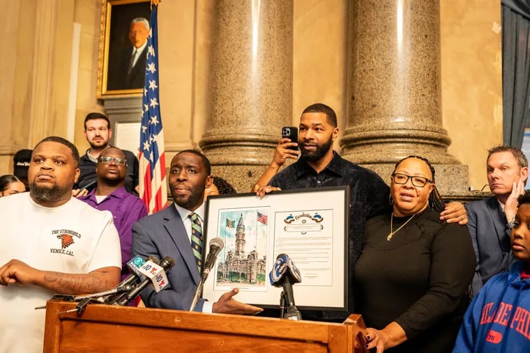 Councilmember Isaiah Thomas (second from left) recognizes Marcus Morris for his nonprofit work. Morris' mother, Thomasine Morris, stands beside him on the right.