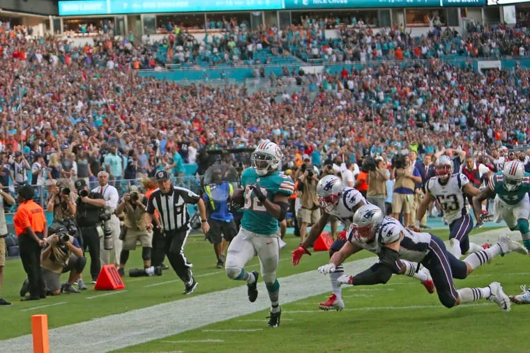 Kenyan Drake runs for a last-second touchdown to help the Dolphins edge out the Patriots in Miami on Sunday.