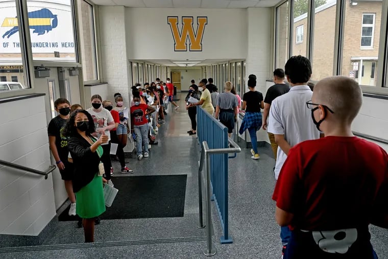 Assistant junior high school principal Jacqueline Edmonds (left) leads an orientation tour of the building at Woodbury High School Aug. 31, 2021. When NJ students return to school next week, they face a mandatory mask mandate