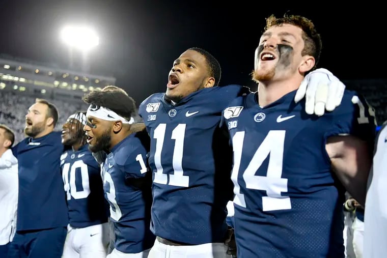 Penn State linebacker Micah Parsons (11) and quarterback Sean Clifford (14) link arms to sing the Penn State fight song after a 28-21 win against Michigan on Saturday, Oct. 19.