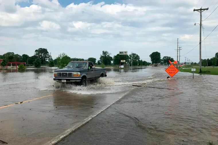 A pickup truck evacuates from an area in north Jefferson City Missouri as floodwaters from the Missouri River rise over the road on Friday, May 24, 2019. The flooding come as residents are still cleaning up from a powerful tornado that hit the state's capital city on May 22.