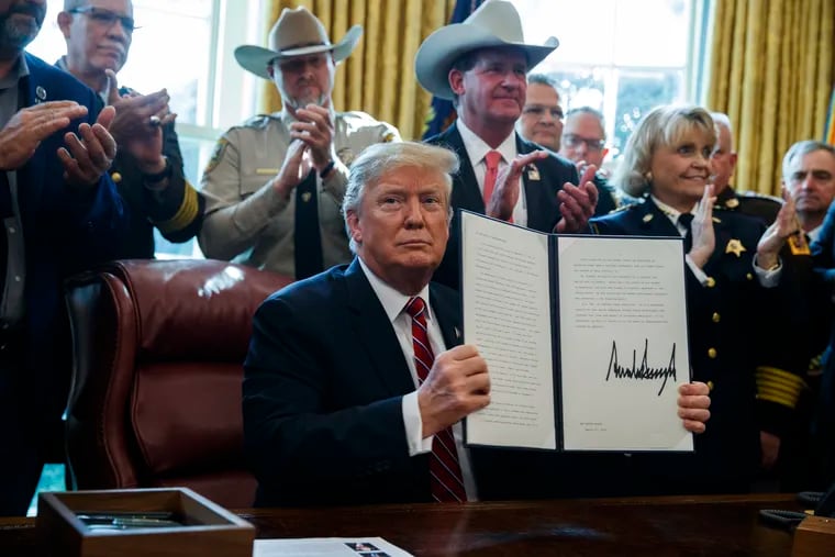 President Donald Trump signs the first veto of his presidency in the Oval Office of the White House, Friday, March 15, 2019, in Washington. Trump issued the first veto, overruling Congress to protect his emergency declaration for border wall funding.