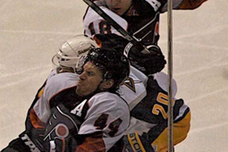 The Flyers&#0039; Kimmo Timonen gets a face-full of glass, thanks to the Sabres&#0039; Daniel Paille (20) and teammate Mike Richards.