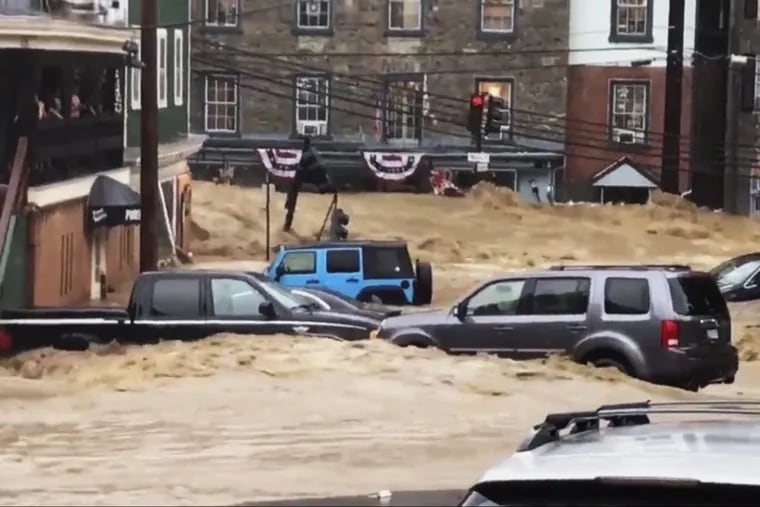 Water rushes through Main Street in Ellicott City, Md., on Sunday.