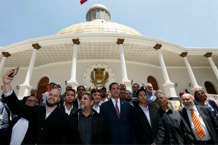Venezuelan opposition leader Juan Guaido, center right, who has declared himself interim president, poses for a photo with members of a coalition of opposition parties, and other civic groups after their meeting in Caracas, Venezuela, Monday, March 18, 2019. After Guaido declared himself interim president in late Feb., Venezuelan President Nicolas Maduro has remained in power despite heavy pressure from the United States and other countries arrayed against him, managing to retain the loyalty of most of his military leaders. (AP Photo/Natacha Pisarenko)