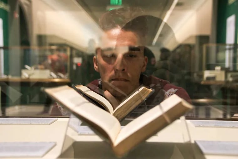 Jenson Titus Lavallee, peruses a rare book during Gumshoe, theatrical performance staged throughout the Central Branch of the Free Library of Philadelphia on Logan Square.
