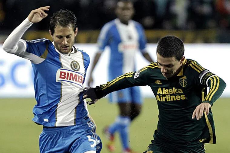 Union midfielder Vincent Nogueira, left, and Portland Timbers midfielder Will Johnson fight for the ball during the first half of an MLS soccer game in Portland, Ore., Saturday, March 8, 2014. (Don Ryan/AP)