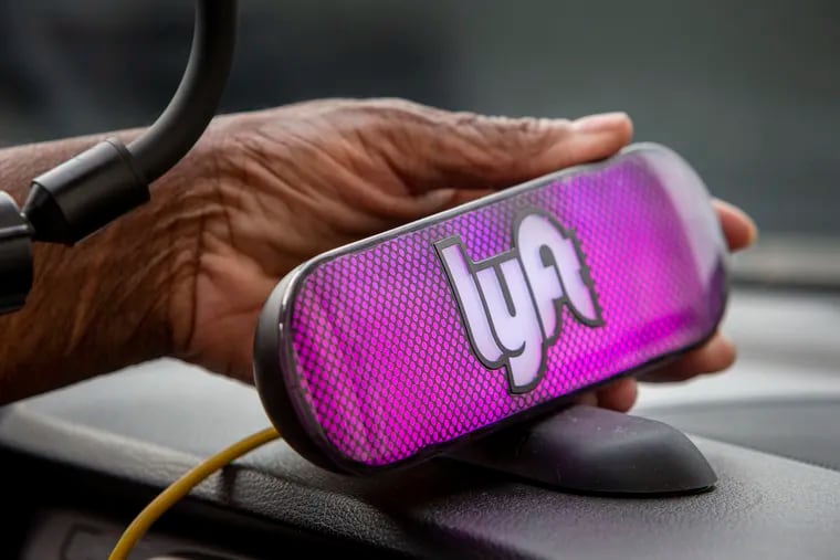 A Lyft driver at 30th Street Station in Philadelphia shows off her Lyft light.
