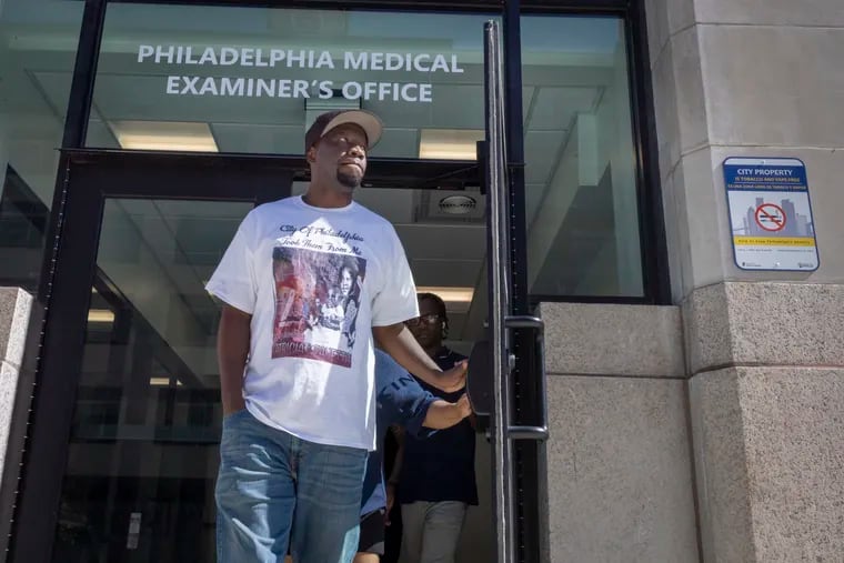 Lionell Dotson and family (background) leave the office of the Philadelphia Medical Examiner on Wednesday. He and family were in Philadelphia to pick up the remains of sisters Katricia and Zanetta who died in MOVE bombing.