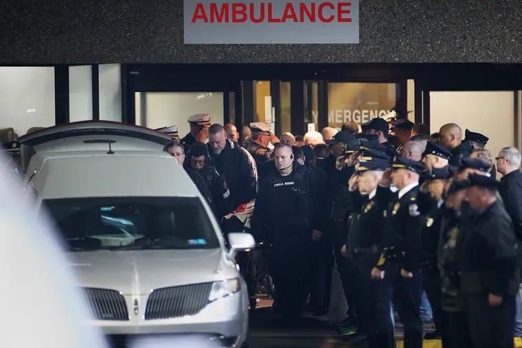 Philadelphia Police SWAT officers accompany the body of Cpl. James O’Connor to a hearse at the emergency room entrance at Temple University Hospital in North Philadelphia on Friday. O'Connor was shot and killed early Friday while serving a warrant, according to Commissioner Danielle Outlaw, becoming the first officer killed in the line of duty in Philadelphia in five years.