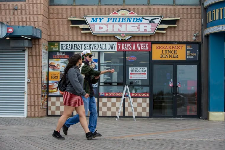A young couple strolls along the Atlantic City boardwall in front of My Friends Diner on Monday morning May 24, 2021. Atlantic City businesses and others along the Jersey shore prepare for the kickoff to summer this coming Memorial Day.