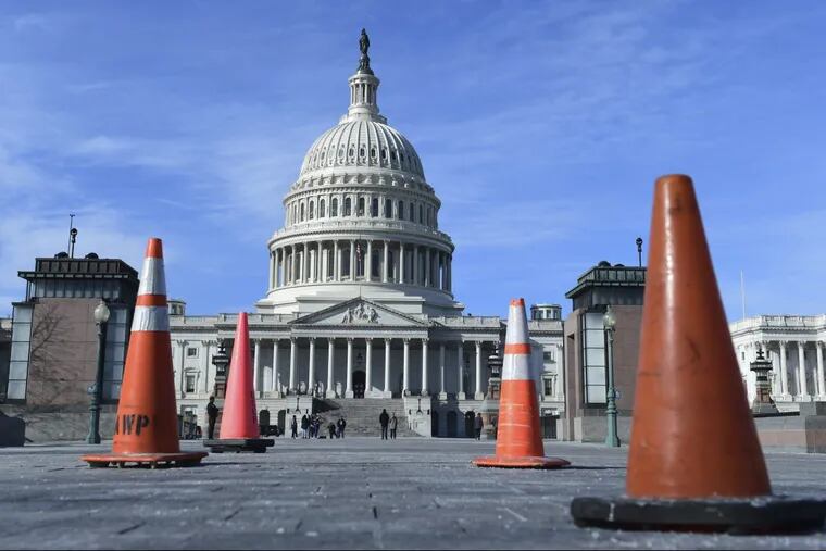 Construction cones used to cover walkway flaws, stand along the sidewalk on Capitol Hill in Washington, Friday, Jan. 19, 2018.