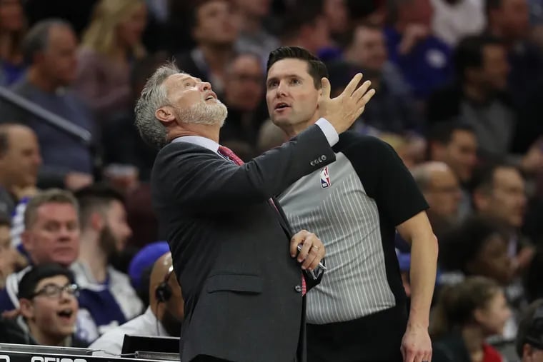 Brett Brown watches a replay as he complains about the Sixers being called for a lane violation against the Cavaliers.