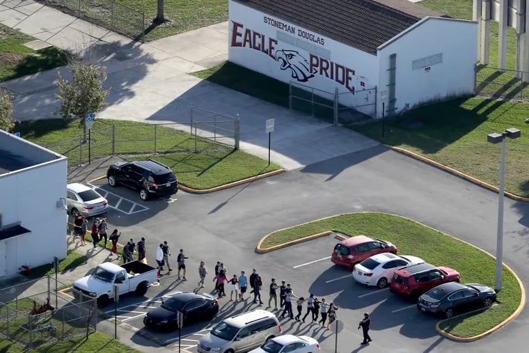 FILE - In this Wednesday, Feb. 14, 2018 file photo, students are evacuated by police from Marjory Stoneman Douglas High School in Parkland, Fla., after a shooter opened fire on the campus. There were plenty of missteps in communication, security and school policy before and during the Florida high school massacre that allowed the gunman to kill 17 people.