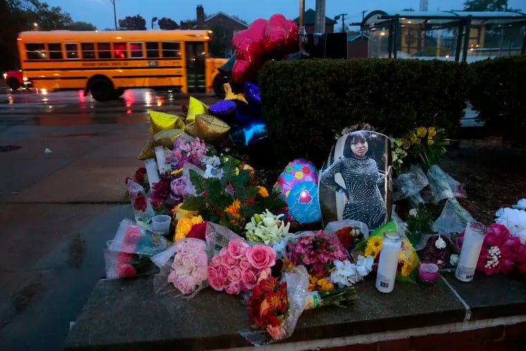 A photo of Alexandria Bell rests at the scene of a growing floral memorial to the victims of a school shooting at Central Visual & Performing Arts High School, Tuesday, Oct. 25, 2022, in St. Louis. Bell and teacher Jean Kuczka were killed, along with the gunman, in Monday's shooting.
