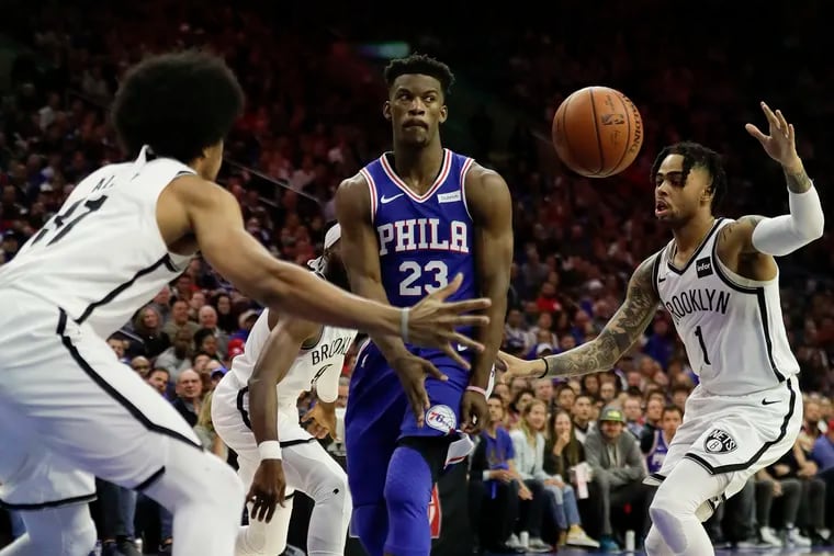 Sixers guard Jimmy Butler (23) passing the basketball past Brooklyn Nets guard D'Angelo Russell (right) and center Jarrett Allen, has taken it upon himself to get teammates involved.