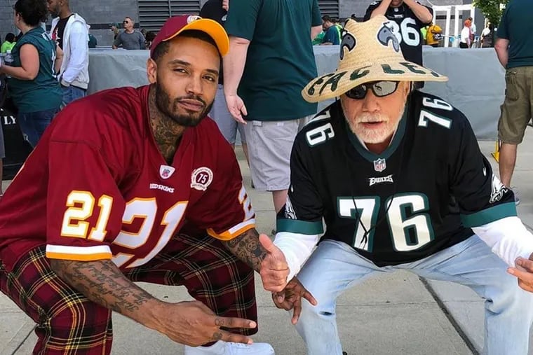 Sixers forward Mike Scott, wearing a Sean Taylor Redskins jersey, poses with Alan Horwitz (known as the "Sixth man" who sits courtside at Sixers games) before the Eagles' season opener at Lincoln Financial Field.