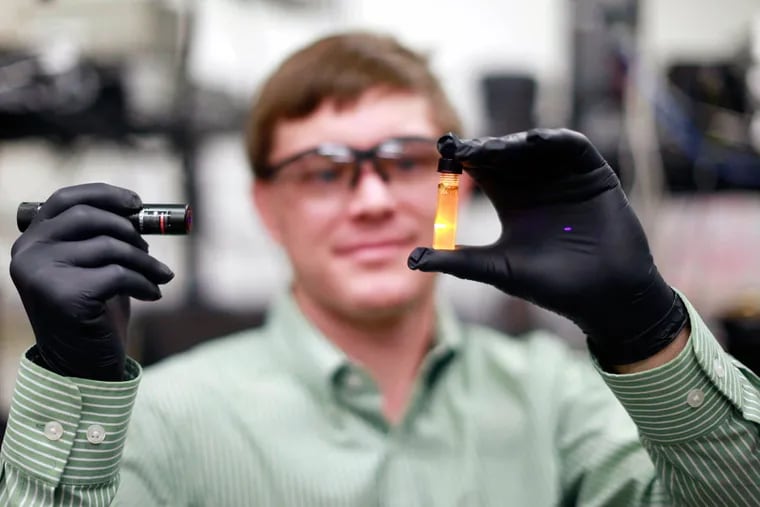 Associate professor Matt Doty holds a vial of nanoparticles he hopes to develop so when applied they improve the efficiency of solar panels.