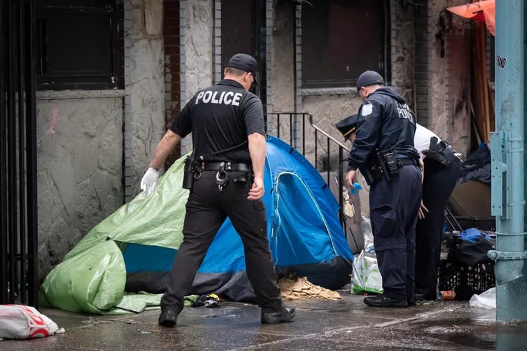 Police look into a tent at an encampment on Kensington Ave., in Philadelphia, Wednesday, May 08, 2024. Police and city workers cleared an encampment along a two-block stretch of Kensington Avenue Wednesday.