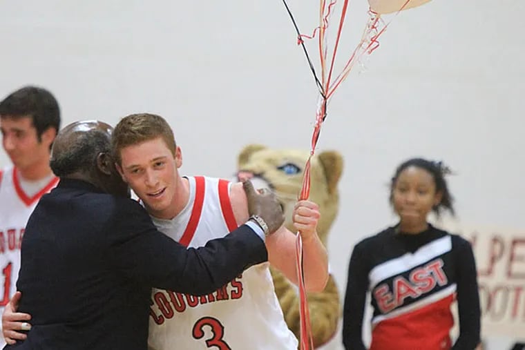 Jake Silpe, center, of Cherry Hill East, is congratulated by Principal
Dr. Lawyer Chapman, left, during a halftime ceremony.  Silpe went over
1,000 career points on the last shot of the 1st half against Paul VI
in boys' basketball on Dec. 19, 2014.    (Charles Fox/Staff Photographer)