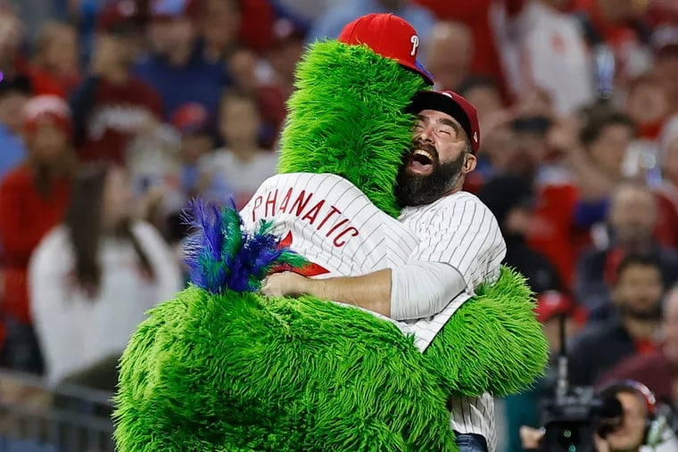 Jason Kelce jumps and hugs the Phillie Phanatic during the 2022 National League Championship Series. He'll join fellow former Eagle Fletcher Cox in throwing out the first pitch on Saturday.